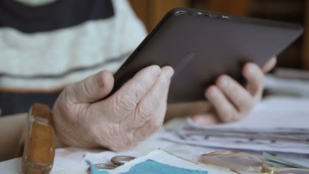 Tablet üzerinde çalışan yaşlı bir kadın elinde — Stok video
