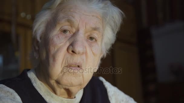 Портрет старой морщинистой одинокой бабушки, смотрящей в камеру — стоковое видео
