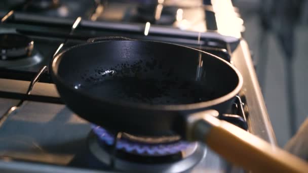 Крупный план масла подсолнухов, льющегося на горячую сковороду. 4K — стоковое видео
