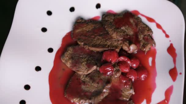 Перевернуть блюдо из мяса и красного соуса на тарелке в 4K — стоковое видео