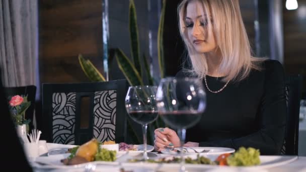 Стильні дівчата їдять, п'ють вино і виступають у модному ресторані 4K — стокове відео