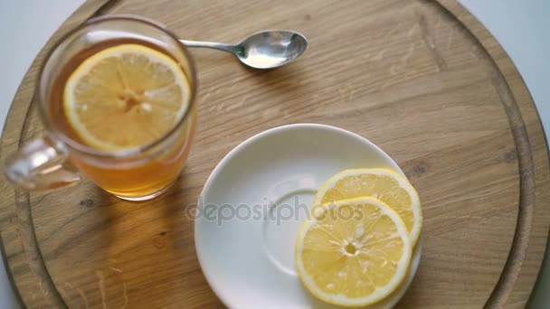 Rotating wooden background with tea and slices of lemon in 4K — Stock Video