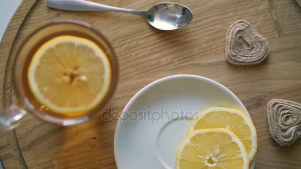 Fondo giratorio de madera con té, rodajas de limón y galletas en 4K — Vídeos de Stock