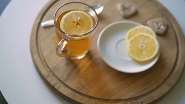 Fondo giratorio de madera con té, rodajas de limón y galletas en 4K — Vídeo de stock