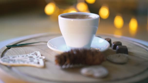 Fondo giratorio de madera con café caliente, caramelos y galletas en 4K — Vídeo de stock
