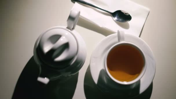 Rotující bílé pozadí s šálkem čaje, lžíce a konvici v rozlišení 4k