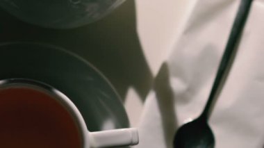 Beyaz arka plan ile fincan çay, kaşık ve çaydanlık dönen kapatın