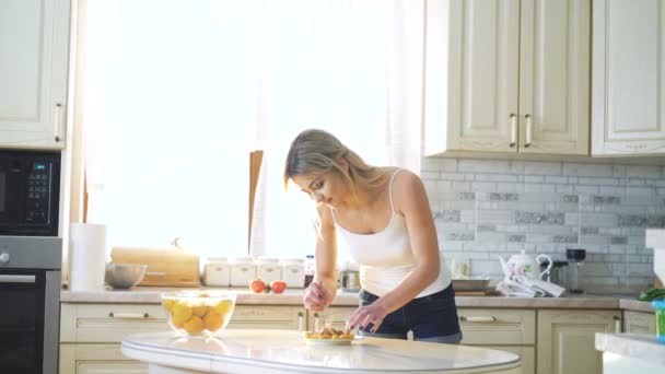 Hezká blondýnka dělat jídlo prezentace na kuchyň v rozlišení 4k — Stock video