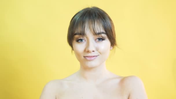 Портрет позитивно емоційної дівчини на жовтому тлі в 4K — стокове відео