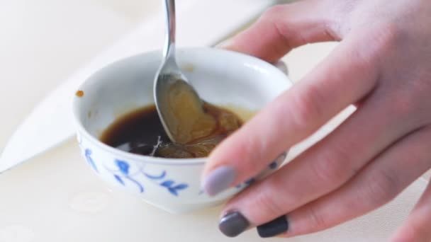Pouring honey into soy sauce — Stock Video