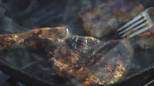 Närbild av stekning och slå över köttet på grillen — Stockvideo