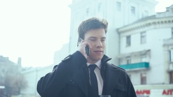 Joven hombre de negocios tomando café y hablando por teléfono. 4k — Vídeos de Stock