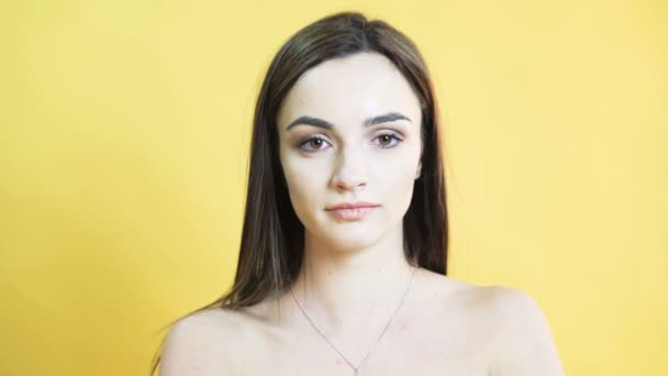 Портрет говорящей девушки со сбалансированными эмоциями на желтом фоне в 4К — стоковое видео