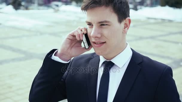 Молодой бизнесмен пьет кофе и разговаривает по телефону. 4k — стоковое видео