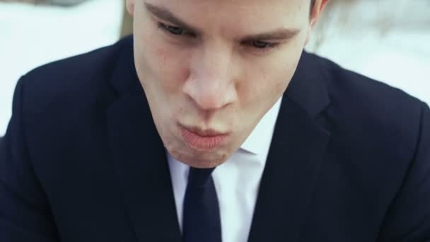 Young businessman sitting on a bench eating at fast food. 4k — Stock Video