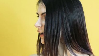 Sarı arka plan üzerinde şaşırtıcı bir duygu ile sevimli bir kadın. Yavaş yavaş