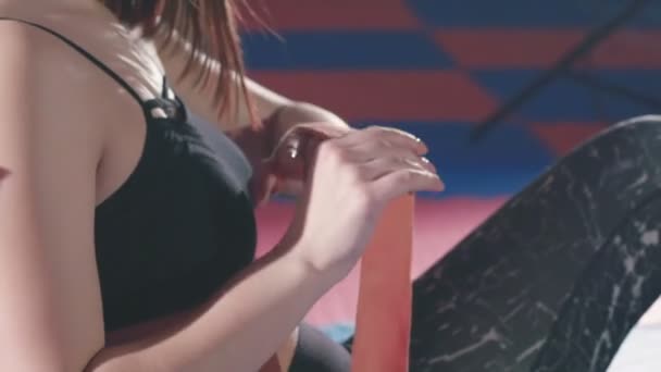 Schöne Frau zieht rote Boxbandagen im Fitnessstudio an — Stockvideo