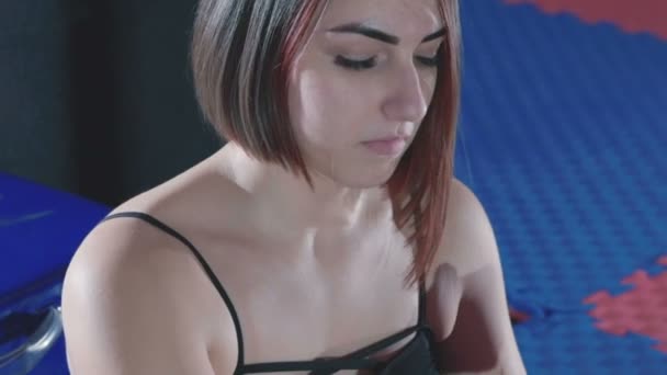 Piękna kobieta, zakładanie czerwonych wykrawania okłady w fitness studio — Wideo stockowe