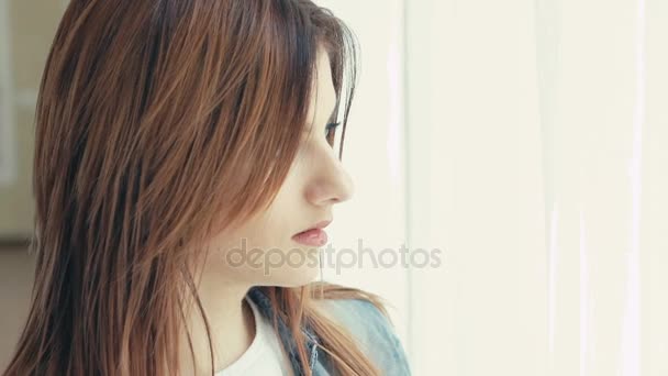 Portrait of pretty girl looking to camera on window background. Slowly — Stock Video