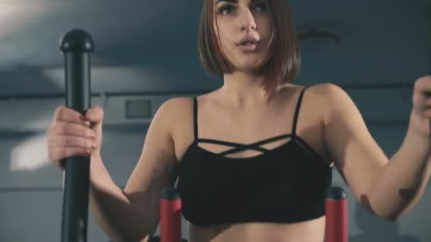 Mooi meisje oefeningen op stepper in het gymnasium in 4k — Stockvideo