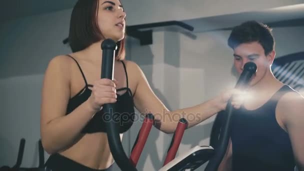 Bella ragazza con esercizi di allenatore sul stepper in palestra in 4K — Video Stock