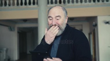 Yaşlı adam şok ve mutlu 4 k tablet bakarak