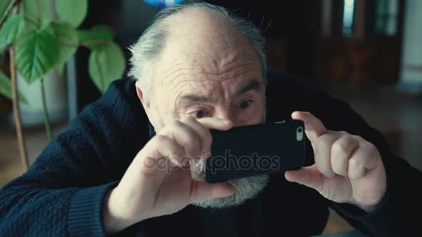 Oude man in het geheim verwijderen met telefoon in 4k — Stockvideo