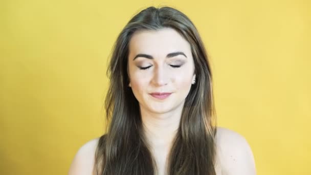 Портрет девушки с эмоциями радости на желтом фоне в 4К — стоковое видео