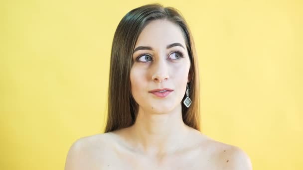 Портрет мыслящей женщины на желтом фоне. 4K — стоковое видео