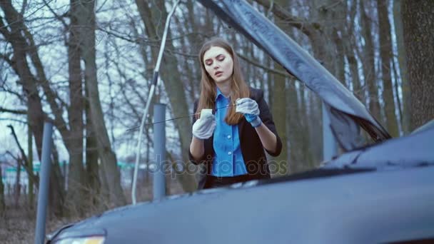 Csinos lány visel kesztyűt, és ellenőrizze a mennyiségű olaj az autóban, 4 k — Stock videók