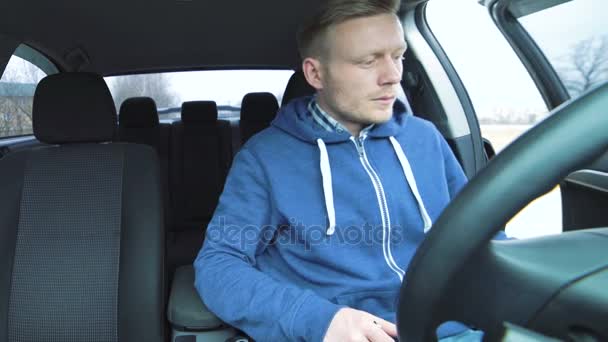 Handsome man sitting into the car, starts auto and smoking — Stock Video