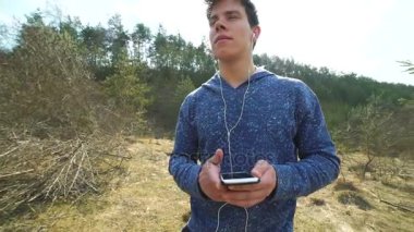 Kulaklık müzik dinlemek ve doğa üzerinde dans adam. Yavaş yavaş