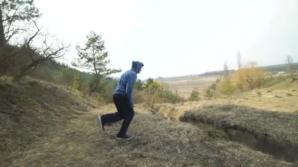 Unga stunt visar svårt trick av parkour på naturen. Långsamt — Stockvideo