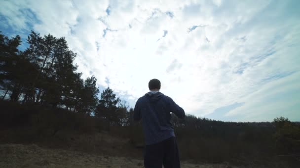 Indietro sguardo di uomo che cammina di nuovo sul prato foreste e boxe. Lentamente. — Video Stock