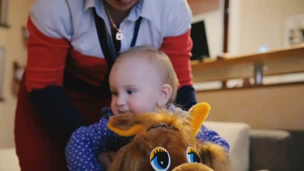 Grand-mère balance bébé sur le cheval jouet — Video