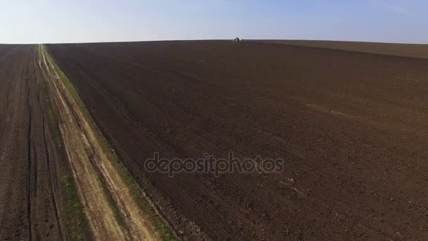 Вид с воздуха на трактор, возделывающий поля с черноземом для посадки в 4К — стоковое видео