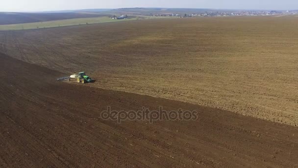 4 k で植わることのための黒い土の分野を開拓トラクターの航空写真 — ストック動画