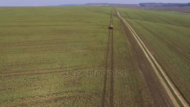 Luchtfoto beelden van trekker besprenkelt het koolzaad veld met chemicaliën in 4k — Stockvideo