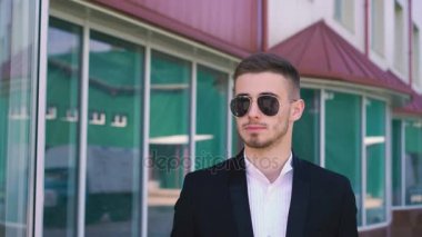 Şık, ciddi yakışıklı erkek güneş gözlüğü 4 k cep telefonu konuşma