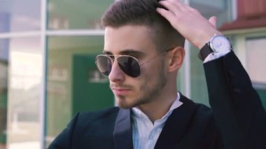 Yakışıklı adam elinde telefon karşı saç düzeltme güneş gözlüğü 4 k kapatın