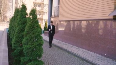 Kullanarak ve 4 k yürürken cep telefonda konuşma şık işadamı