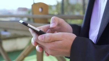 Erkek ellerini tutar ve bir arka plan bulanık üzerinde 4 k smartphone kullanarak yakın çekim