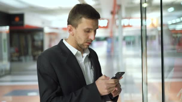 Lovely man looks womans dress on the showcase holding a credit card in hand 4K — Stock Video