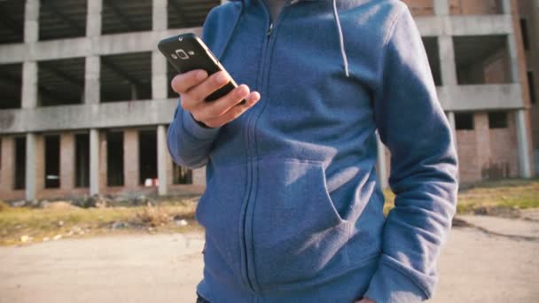 L'homme marche dans la rue et utilise un smartphone avec des émotions 4K — Video