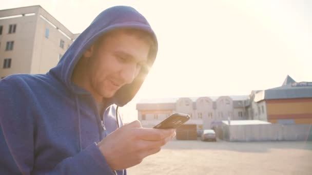 L'homme marche dans la rue et utilise un smartphone avec des émotions 4K — Video