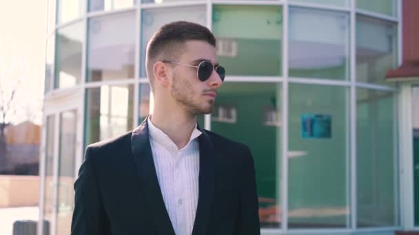 Elegante hombre quitando gafas de sol y mirando seriamente a un lado en 4K — Vídeo de stock