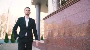Genç işadamı yürüyüş office yakınındaki ve gülümseme 4 k ile çağrı alır