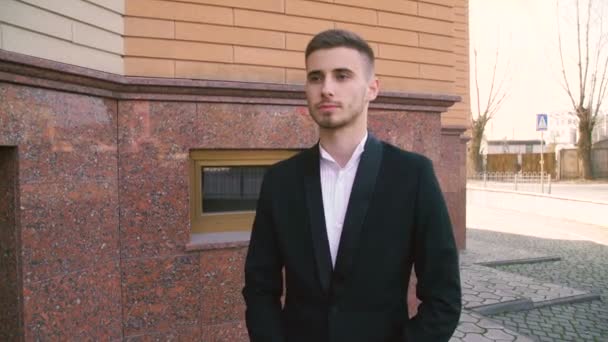 Junger Geschäftsmann geht auf der Straße auf Kamera zu — Stockvideo