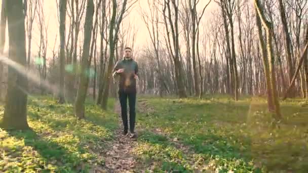 Guapo joven corriendo en el bosque 4K — Vídeos de Stock