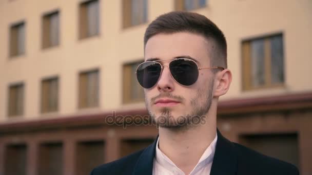 Elegante guapo, joven hombre quitando gafas de sol y mirando a la cámara 4K — Vídeos de Stock